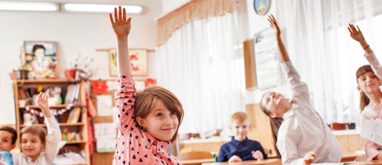 girl raising her hand in class